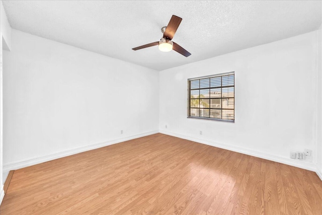 spare room featuring a textured ceiling, light hardwood / wood-style flooring, and ceiling fan