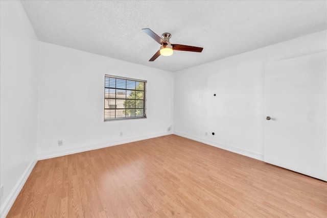 unfurnished room featuring ceiling fan, light hardwood / wood-style floors, and a textured ceiling