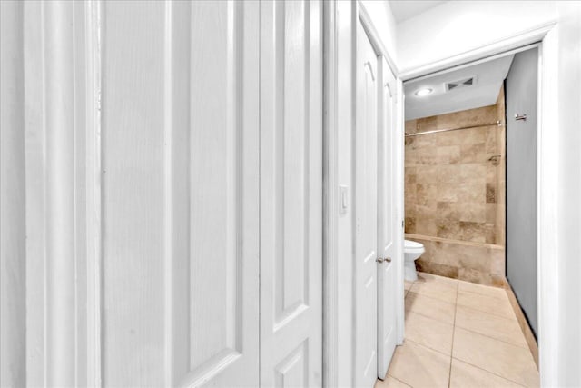 bathroom featuring tile patterned floors, toilet, and bathing tub / shower combination