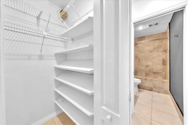 spacious closet with light tile patterned floors