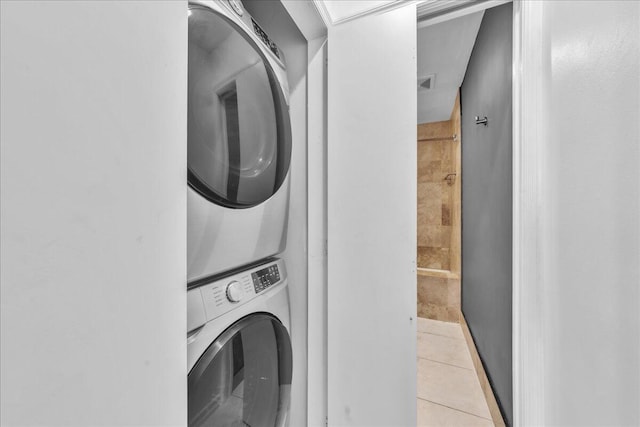 washroom featuring stacked washer / drying machine and light tile patterned floors