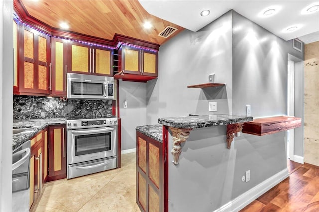 kitchen with backsplash, dark stone counters, appliances with stainless steel finishes, a kitchen bar, and wood ceiling