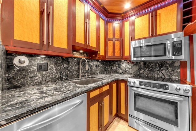 kitchen featuring backsplash, stainless steel appliances, dark stone countertops, and sink