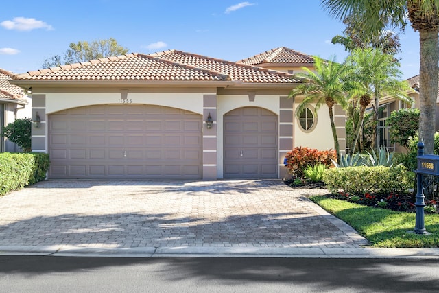 11556 Green Golf Ln, Boynton Beach, FL 33437 - mediterranean / spanish home with a garage, stucco siding, decorative driveway, and a tiled roof