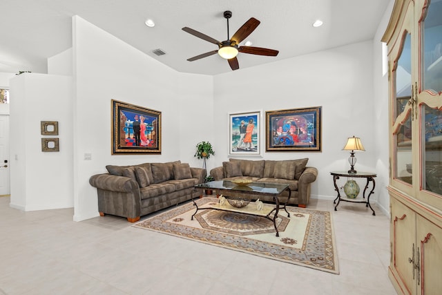 living room with ceiling fan, light tile patterned flooring, and a high ceiling