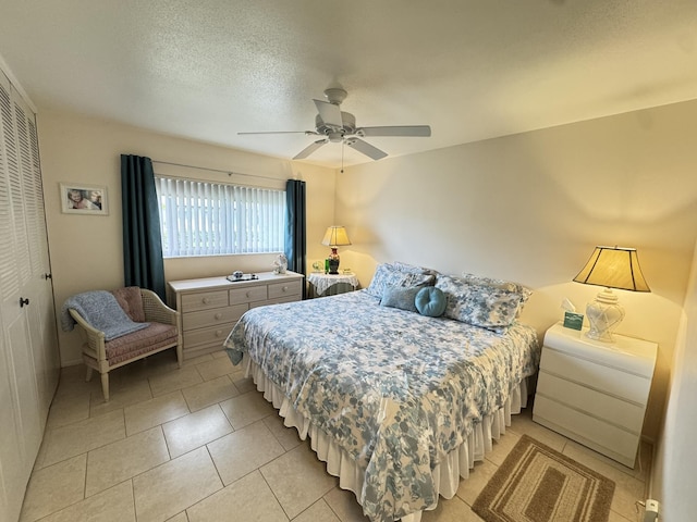 tiled bedroom with a textured ceiling, a closet, and ceiling fan