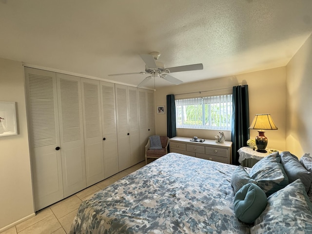 tiled bedroom with ceiling fan, a textured ceiling, and a closet