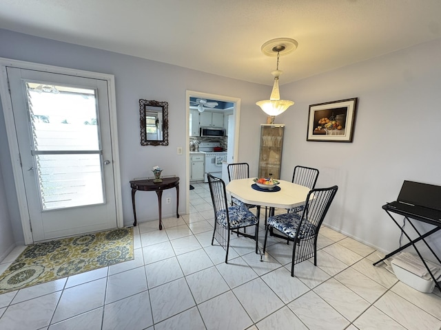 tiled dining area with a wealth of natural light and ceiling fan