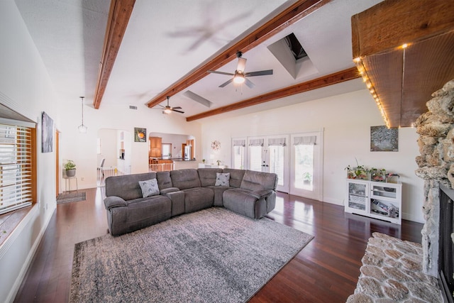 living room with french doors, ceiling fan, beam ceiling, a fireplace, and dark hardwood / wood-style floors