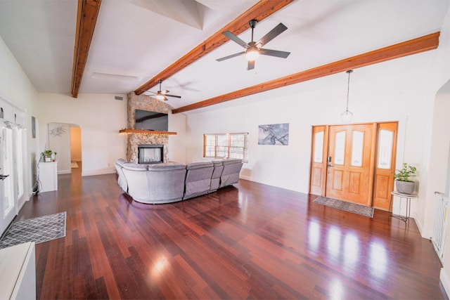 living room with ceiling fan, a fireplace, lofted ceiling with beams, and dark hardwood / wood-style floors