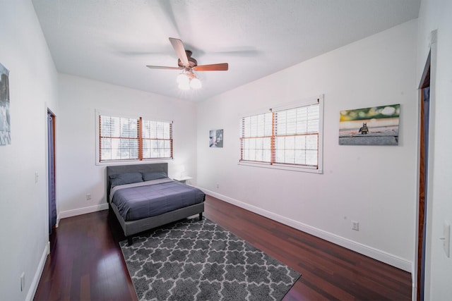 bedroom with a textured ceiling, dark hardwood / wood-style flooring, and ceiling fan