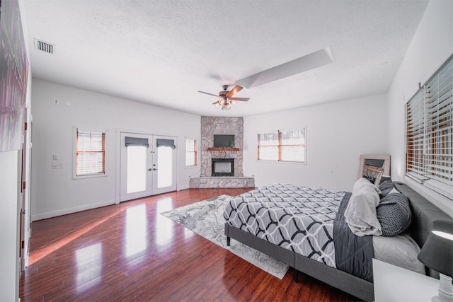 bedroom with french doors, a textured ceiling, access to outside, ceiling fan, and hardwood / wood-style flooring