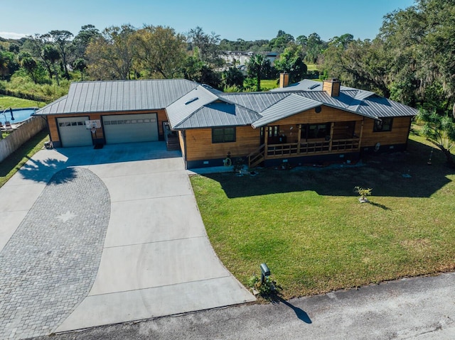 view of front of property with a porch, a front yard, and a garage