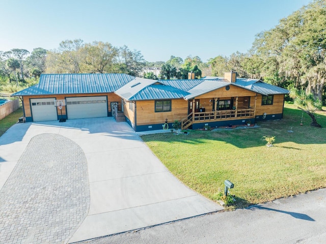 view of front of house featuring covered porch, a garage, and a front lawn