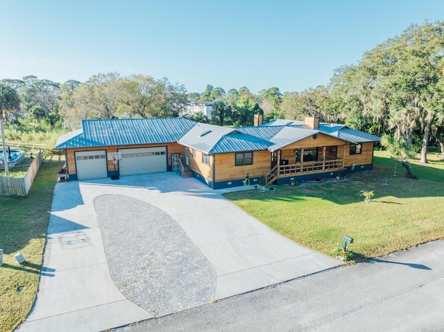 view of front of property featuring a front lawn, covered porch, and a garage