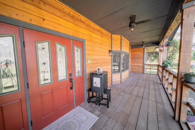 wooden terrace with a porch and ceiling fan