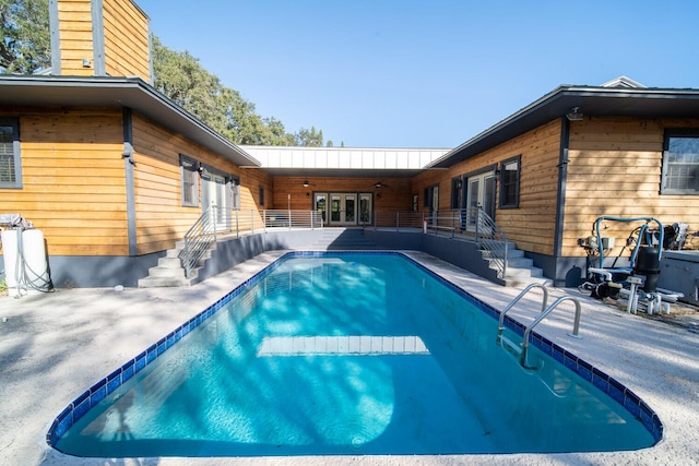 view of pool with ceiling fan, a patio area, and french doors