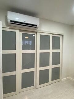 interior space featuring a wall unit AC and baseboards