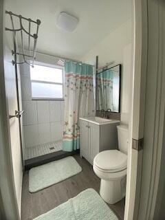 full bathroom with curtained shower, vanity, toilet, and wood finished floors