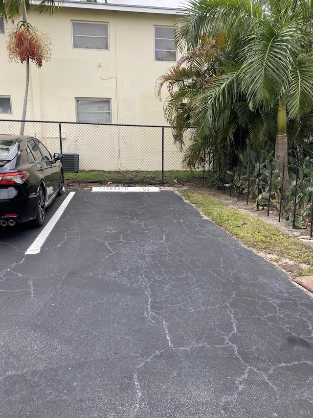 uncovered parking lot featuring fence