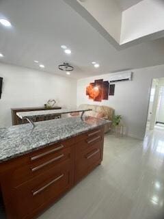 kitchen featuring light stone countertops, recessed lighting, light wood finished floors, and a wall mounted AC