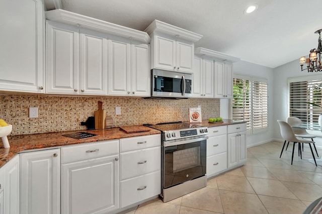 kitchen with appliances with stainless steel finishes, white cabinets, and backsplash