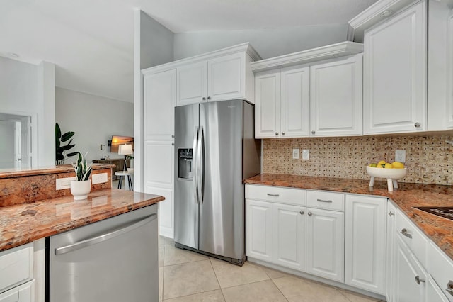 kitchen with vaulted ceiling, white cabinets, and appliances with stainless steel finishes