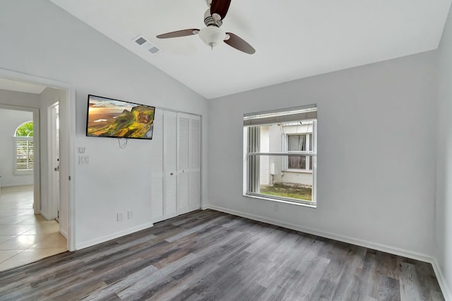 empty room featuring vaulted ceiling, wood-type flooring, and ceiling fan