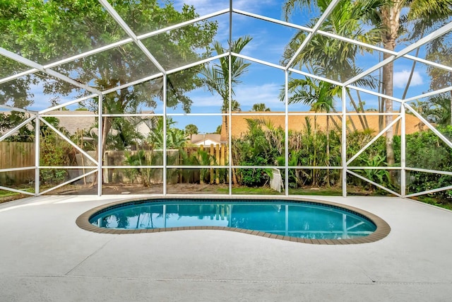 view of pool with a patio and glass enclosure