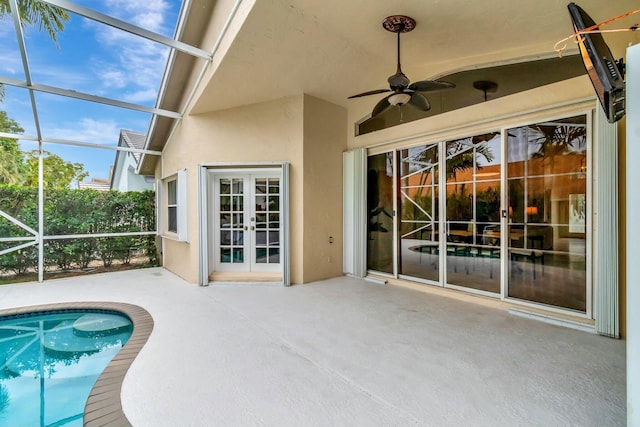 exterior space with a patio area, french doors, ceiling fan, and glass enclosure