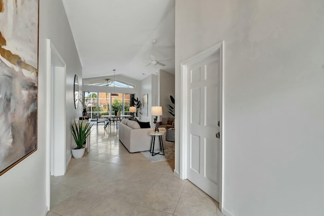 hallway with light tile patterned floors and vaulted ceiling