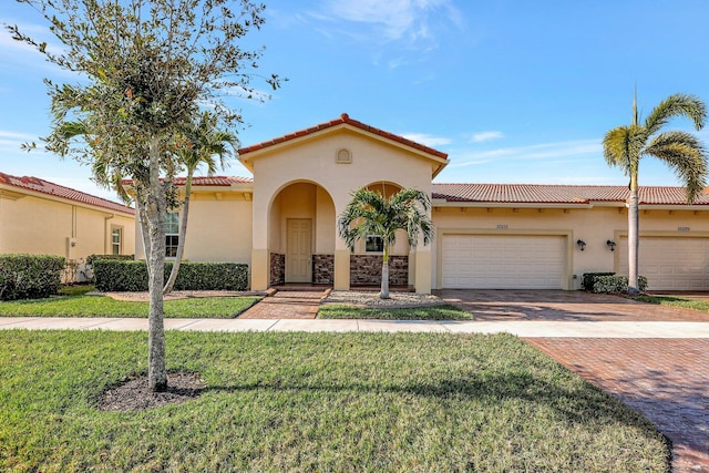 mediterranean / spanish-style house featuring a front lawn and a garage