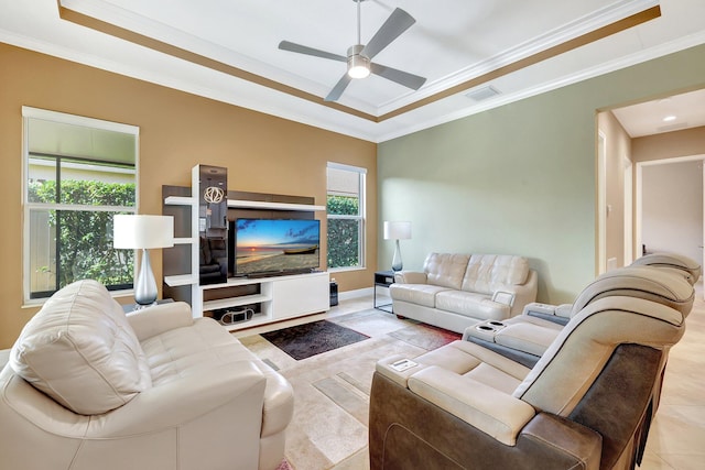 living room featuring ceiling fan, a tray ceiling, and ornamental molding