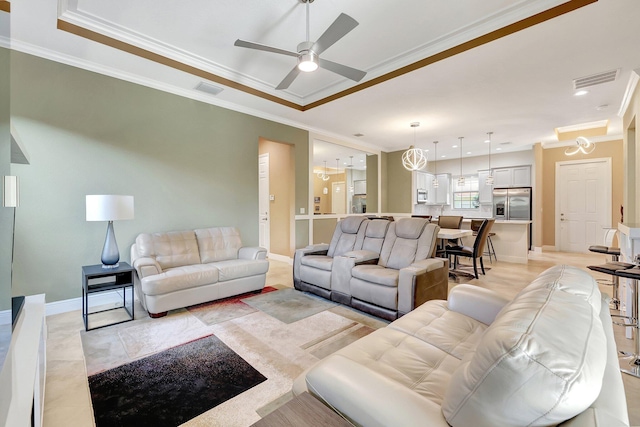 living room with crown molding, ceiling fan with notable chandelier, and a raised ceiling