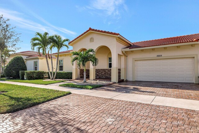 mediterranean / spanish house featuring a front yard and a garage