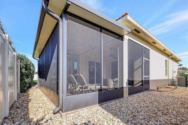 rear view of house featuring a sunroom and cooling unit