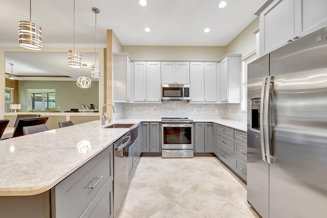 kitchen with appliances with stainless steel finishes, gray cabinetry, tasteful backsplash, a kitchen breakfast bar, and pendant lighting