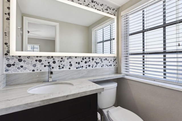 bathroom with vanity, ornamental molding, and toilet