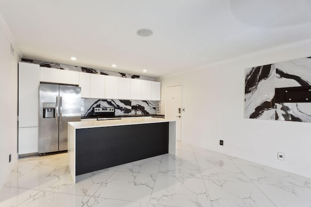 kitchen with white cabinets, stainless steel fridge, decorative backsplash, and crown molding