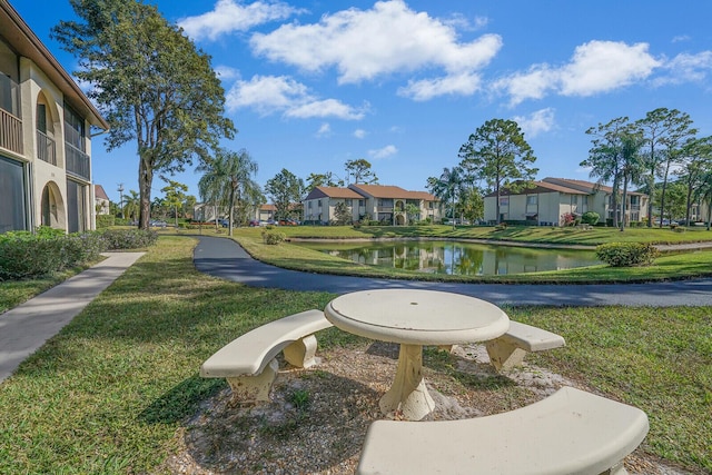 view of property's community featuring a lawn and a water view