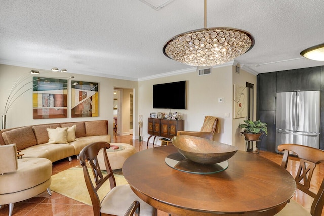 dining room with light tile patterned floors, a textured ceiling, and ornamental molding