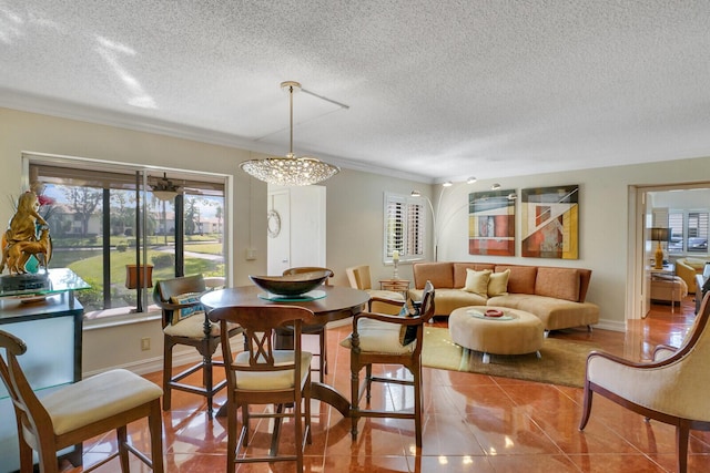 dining area with tile patterned floors, ornamental molding, a textured ceiling, and an inviting chandelier