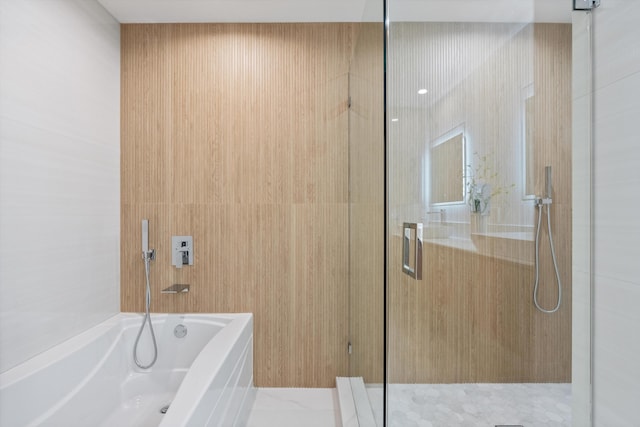 bathroom featuring a shower with door, tile walls, and a bath