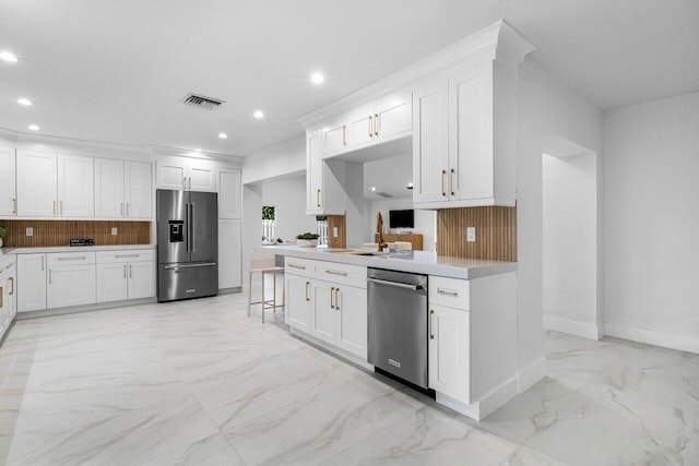 kitchen with marble finish floor, stainless steel appliances, recessed lighting, backsplash, and white cabinetry