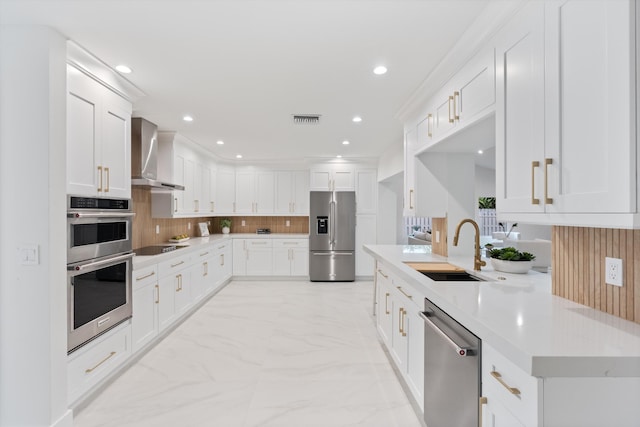 1338 SW 13th St, Boca Raton, FL 33486 - kitchen featuring stainless steel appliances, wall chimney exhaust hood, light marble finish floors, backsplash, and white cabinetry
