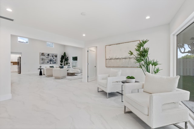 living area with recessed lighting, marble finish floor, visible vents, and baseboards