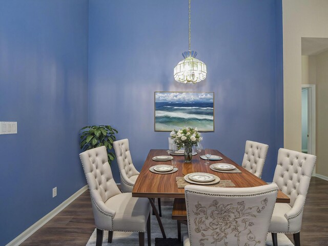 dining space featuring dark hardwood / wood-style flooring and an inviting chandelier