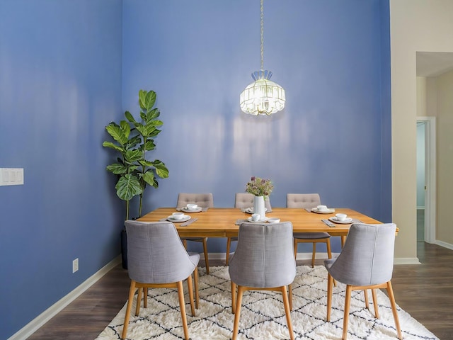 dining area with hardwood / wood-style flooring and an inviting chandelier