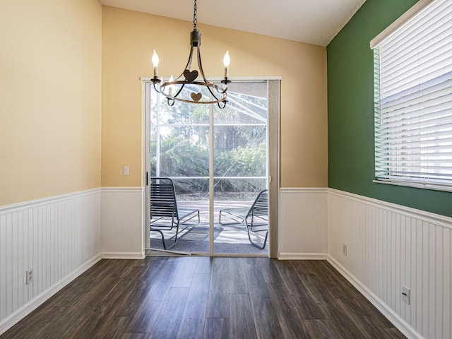 unfurnished dining area with an inviting chandelier and dark wood-type flooring