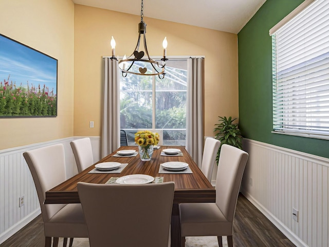 dining space featuring dark wood-type flooring and a chandelier